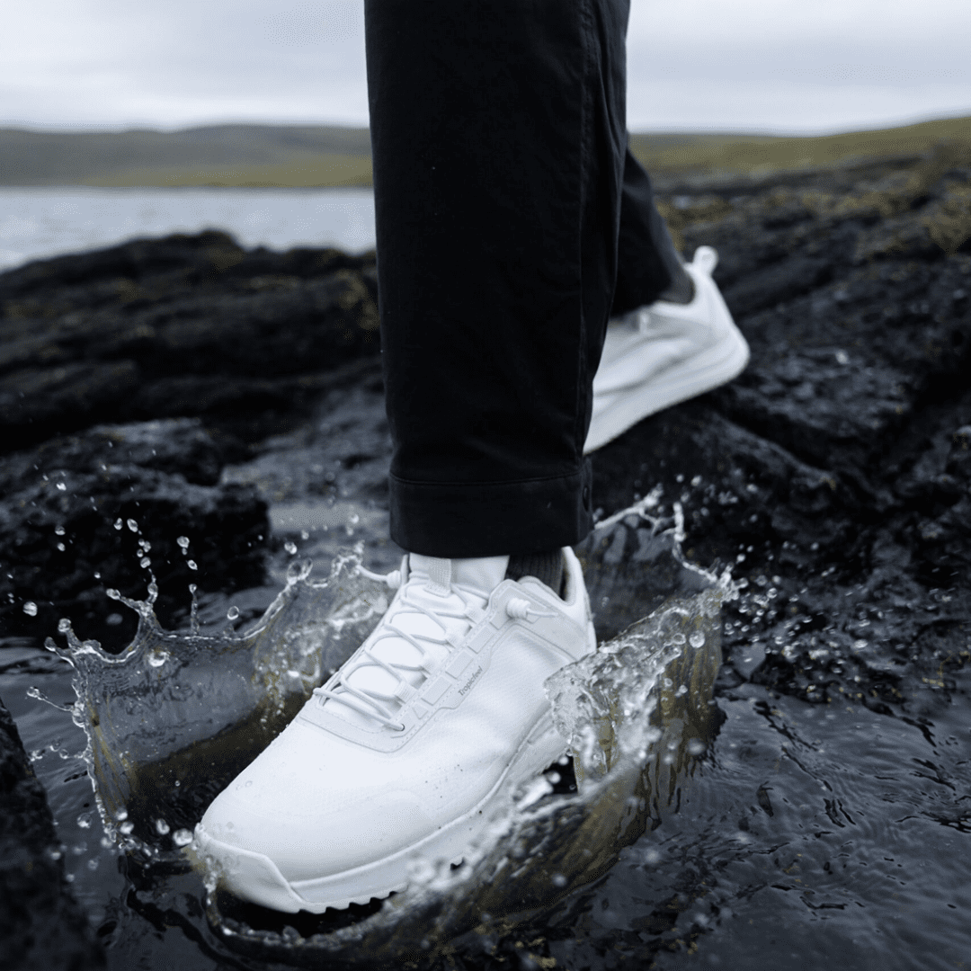 Black pants, white shoe in puddle